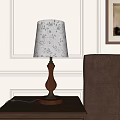 Elegant Table Lamp with Wooden Base Gold Accents and Floral Patterned Lampshade by Beige Chair