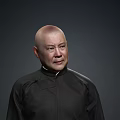 Bald Man Wearing Black Traditional Robe Standing Against Dark Gray Background