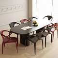 Modern Black Oval Dining Table with Eight Red and Black Chairs Fruit Bowl and Napkin