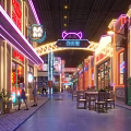 Vibrant Commercial Street With Neon Lights Traditional Modern Architecture Pedestrians And Outdoor Tables