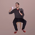 Man sitting on chair holding white cup wearing gray sweater red shirt red shoes