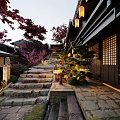 Traditional Commercial Street Featuring Stone Steps Lanterns Red Maple Trees And Illuminated Evening Ambiance