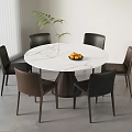 Stylish Round White Marble Dining Table With Black Brown Chairs Fruit Bowl And Green Plant
