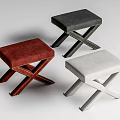 Three Colored Upholstered Stools In Red Black White With Cross Legged Design And Rivet Details