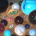 Assorted Colorful Glass Marbles With Diverse Patterns and Textures On Wooden Surface