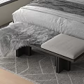 Gray Furry And Padded Bed Footstool Beside White Bed On Geometric Rug Wooden Floor Bedroom