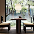 Round Dining Set with Black Chairs Beige Cushions Hanging Lamp by Large Window with Trees Outside