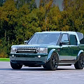 Stylish Black Land Rover SUV Parked on Stone Pavement with Autumn Forest Background