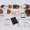 Assorted Notebooks in Black Brown with Pens Folders Clipboards on White Background