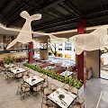 Modern Restaurant Interior Featuring Hanging White Whale Decorations Red Pillars Dining Tables And Green Plants