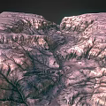 Detailed View Of Rugged Planetary Surface With Mountainous Terrain And Deep Canyons