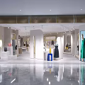 Modern Clothing Store Interior With Clothing Displays Decorative Plants And Lighting Fixtures