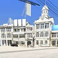 Scenic Commercial Street with Classic White Buildings Clock Tower and Billboards Under Blue Sky
