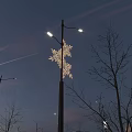 Evening Public Street Lights With Blue Star Shaped Ribbon Decorations And Urban Skyline