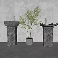 Stone Pedestal Washbasins With Golden Faucets And Small Tree In Gray Pot
