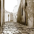 Ancient Stone Paved Alley With Weathered Walls On Both Sides Creating Rustic And Serene Atmosphere