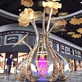 Large Gold And Silver Metal Art Installation With Golden Leaves Purple Light In Mall Interior