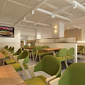 Modern Restaurant Interior With Green Chairs Light Tables White Walls And Artwork