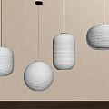 Four Hanging Round Cream Colored Paper Lanterns With Light Wall And Wooden Surface