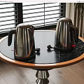 Stainless Steel Electric Kettles on Black Marble Round Tabletop with Window Background