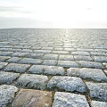 Gray Cobblestone Pavement With Neatly Arranged Stones And Small Moss Growth