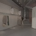 Modern Clothing Store Interior Design Featuring Hanging Outfits Display Shelves And Minimalist Decor