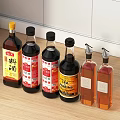 Various Condiment Bottles With Different Labels On Kitchen Counter For Seasonings