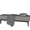 Gray Upholstered Ottoman Footstool With Black Wooden Legs Houndstooth Blanket And Stacked Books
