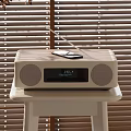 Wooden Stereo Speaker With Mobile Phone On Top And Digital Display On White Table