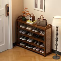 Multi Tiered Shoe Rack With Various Shoes Vase Radio And Handbag In Entryway