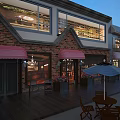 Charming Commercial Street With Red Brick Buildings Red Awnings Outdoor Seating And Wooden Deck