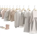 Baby Clothes Hanging on Hangers with Light Colored Dresses Shirts and Shoes