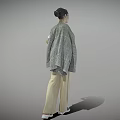 Woman Standing in White Graphic T-Shirt Beige Trousers Gray Coat Over Shoulder Against Gray Background