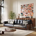 Black Leather Multi Person Sofa With Black White Patterned Pillows Abstract Painting And Green Plant