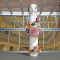Decorative Column With Colorful Paper Flowers And Butterflies In Glass Facade Building Entrance