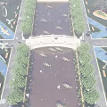 Scenic Stone Arch Bridge Over Misty Pond With Willow Trees And Lotus Flowers