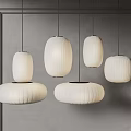 Modern White Pendant Lights In Different Sizes With Round Shades Hanging Over Interior Space