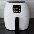 White Air Fryer Kitchen Appliance Featuring Digital Display And Cooking Fries