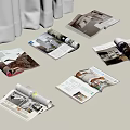 Open Magazines Scattered on White Surface with Pages Showing Images Text and White Curtain
