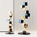 Abstract Cube Sculptures With Gold Black Blue Blocks Against White Striped Wall