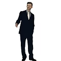 Man in dark suit white shirt and tie standing naturally against light purple background