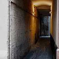 Historic Commercial Street Alley Featuring Narrow Brick Walls Warm Lighting and Damp Ground
