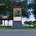Outdoor Billboard Featuring Sculpture Painting In Park With Green Trees And Grass