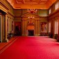Luxurious Grand Hall Interior With Red Carpet Golden Columns Chandelier Fireplace And Paintings