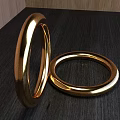 Polished Golden Bracelets Displayed On Dark Surface With Wooden Background