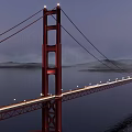 Red Suspension Bridge Illuminated Over Calm Water With City Lights At Night