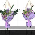 Elegant Floral Display With Purple Wrapped Bouquets On Black Tripods Against White Wall