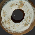 Brown Bundt Cake With White Frosting And Crumbled Toppings On Top