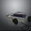 Portable White Electronic Appliance With Blue Display Screen And Attached Black Headphones