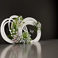 Floral Display Installation With White Circular Rings And White Pink Flowers Around Logo